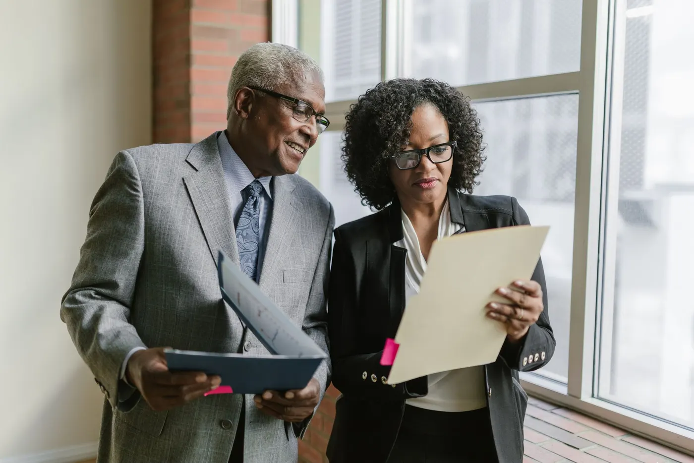 Two compliance professionals reviewing a case file together