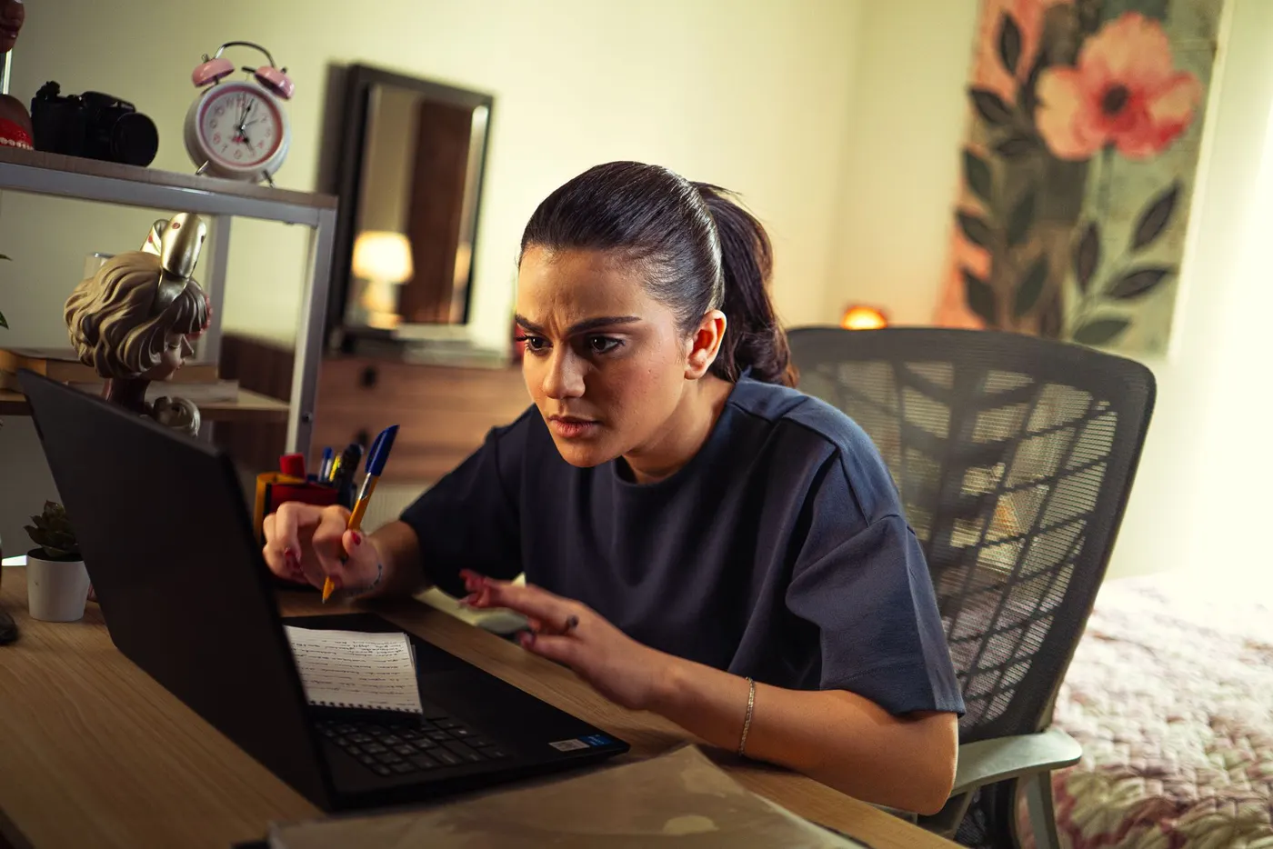 A compliance professional studying at a desk with a laptop and notes